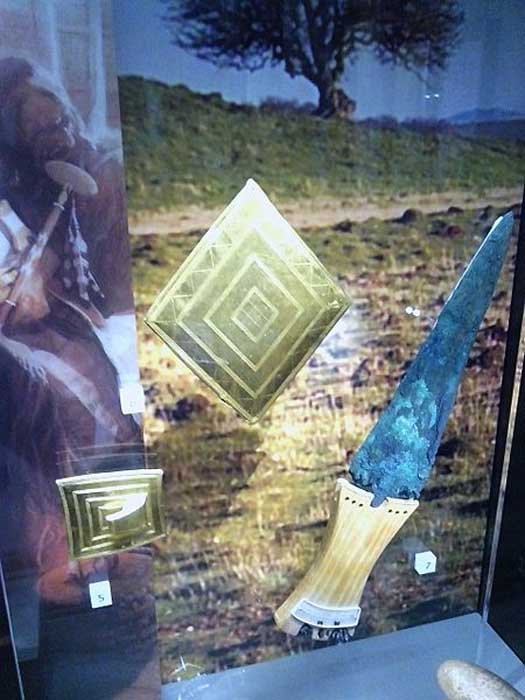 Gold lozenge, gold belt buckle, copper dagger. Bronze Age grave goods from Wilsford G5, Bush Barrow. Now in the Wiltshire Museum, Devizes.
