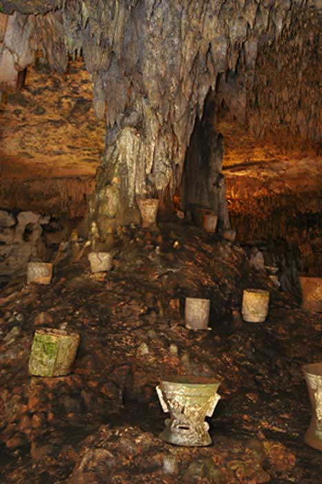 Incense burners around the tree-like column in the Balankanché Cavern