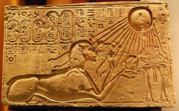 This stone relief of the ancient Egyptian city of Amarna shows Akhenaten as a sphinx with Aten the sun god illuminating him and his offering.