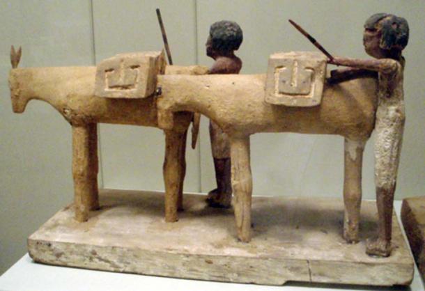 Ancient Egyptian tomb figurines depicting workers loading up a couple of donkeys with supplies. Early Middle Kingdom, circa 2000 BC.
