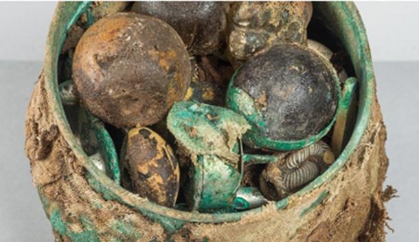 Some of the finds from Gaulcross: A) the lunate/crescent-shaped pendant with two double-loops; B) silver hemispheres; C) a small, zoomorphic penannular brooch; D) one of the bracelet fragments with a Late Roman siliquae pinched inside
