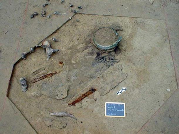 Cauldron, iron spears, sword and helmet attachment found in the burial chamber.