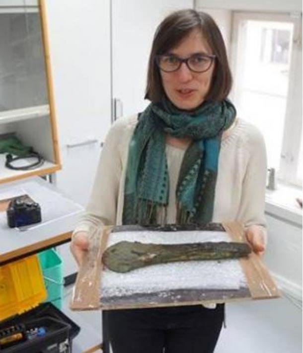 Constanze Rassman holding one of the bronze axes found at the site. 2015.