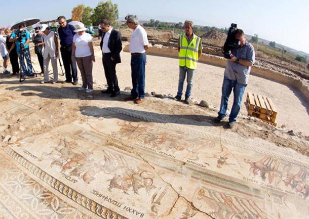 Officials examining part of the mosaic found in Akaki village.