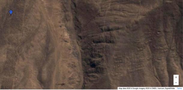 Screenshot from Google Maps showing long band of holes at left, and indications of a settlement to the right