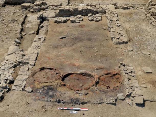 The kitchen of what looks like an ancient tavern, with three reddish circles where the three ovens -- for baking flatbread and other dishes -- once stood.