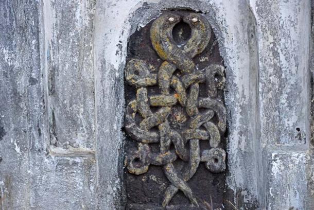 Two entwined snakes stand at one end of the wall, near Gorakhpur, India.