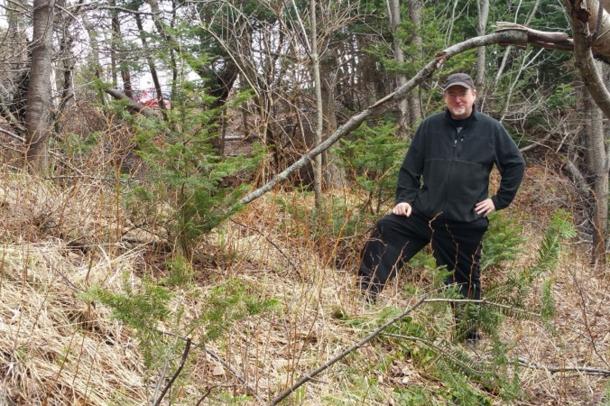 Wayne MacIsaac stands near what he believes may be the remnants of a Norse fortification wall.