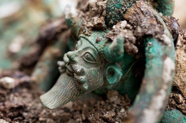 The handles of a large cauldron in the tomb are decorated with the Greek river God Achelous
