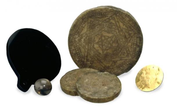 The magical tools of John Dee: golden and wax discs, a quartz sphere, and a polished mirror.
