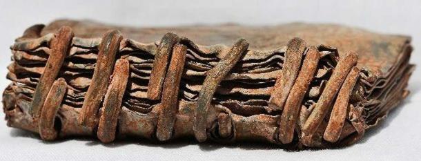 The bound metal tablets.