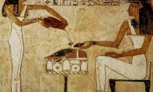 Painting of an ancient Egyptian woman being served beer.