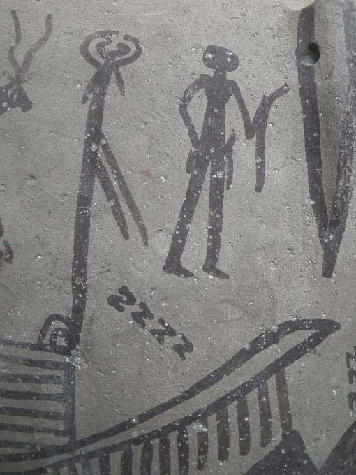 A ritual scene painted on a Predynastic pottery jar depicts multiple S-shaped motifs and a man holding a curved implement similar to the tattoo designs found on the woman.