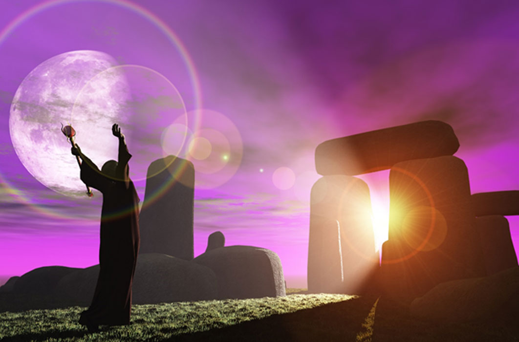Druid greets the dawn at Stonehenge (heywoody  / adobe stock)