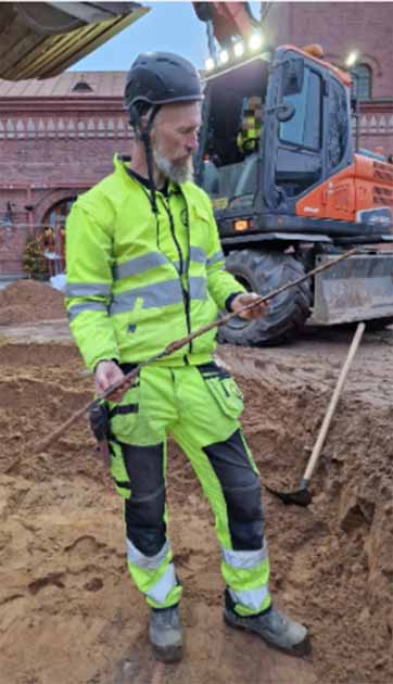 Archaeologist Eirik Johansson from Bohusläns Museum holds up the medieval sword he found during the ongoing archaeological survey of Lilla Torg in Halmstad. (Kulturmiljö Halland)