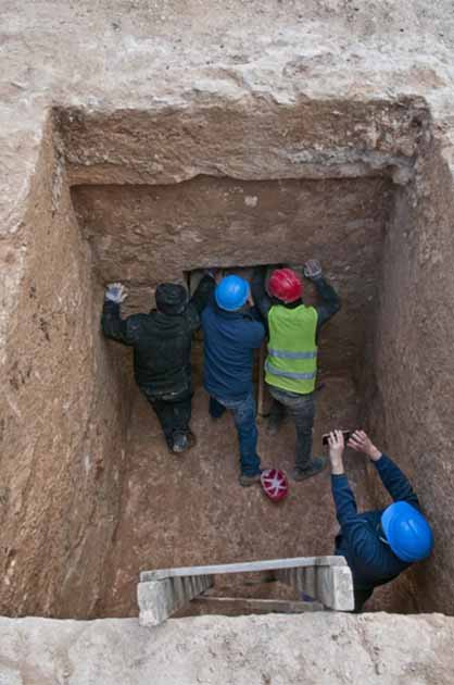 Archaeologists at work in the burial cave of the Hellenistic escort. (Shai Halevi / Israel Antiquities Authority)