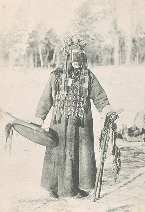 Buryat shaman photographed in 1904 wearing many of the same ritual garments as Manchu shaman, notably an apron, a cap, two wooden sticks, and a ritual drum. (Public Domain)