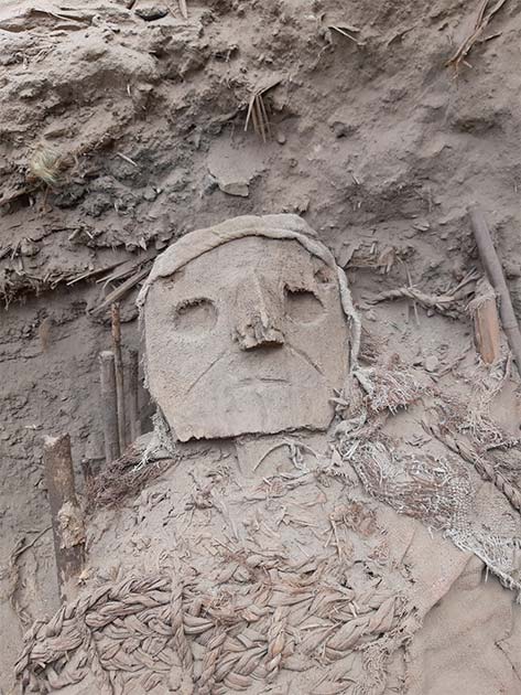 Carved wood mask on the so-called “false head” of a burial tomb, and Pachacámac, Peru. (© PUCP Archaeology Program “Valley of Pachacámac”/ CC BY-SA 4.0)