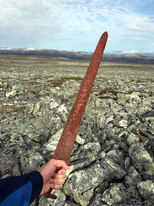 Einar Åmbakk holding the sword, just moments after it was discovered.