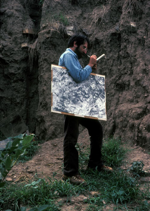 Gary Feinman, co-author of the new study, on survey in the 1980s, holding air photo under his arm as he takes notes on exposed architecture in a pre-Hispanic mound. (Linda Nicholas / Field Museum)