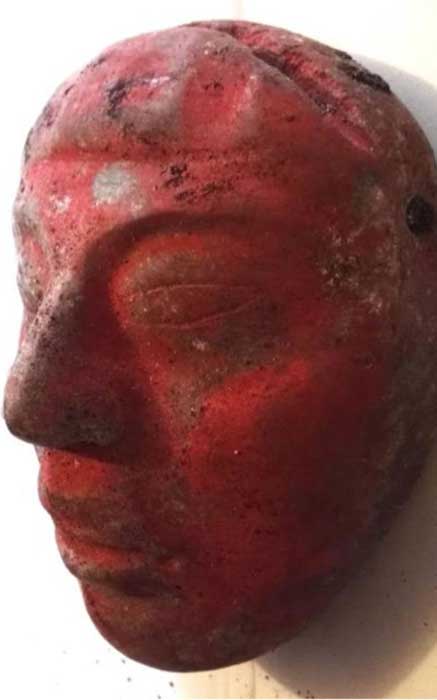 Jade mask from Burial 80, painted red with cinnabar paint. 