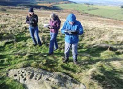 Members of the public completing a site monitoring form in the countryside. (Author provided)
