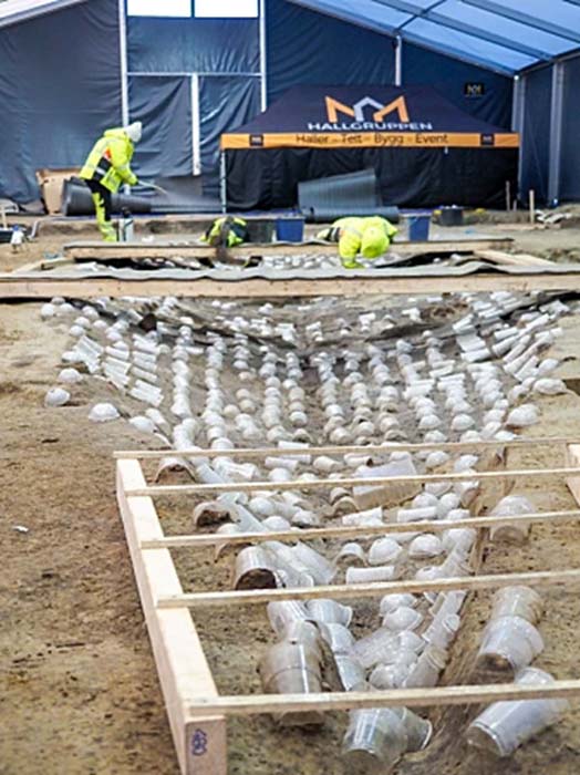Plastic cups have been used to protect and preserve all the ship nails, which form an outline of the ship, before excavation with a new rivet-extracting-invention. (Museum of Cultural History, Oslo)