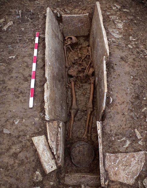 One of the Roman slave skeletons in the stone coffin structure with a pot (at bottom of the shot) unearthed at the burial site in Somerset, England. (Wessex Archaeology)