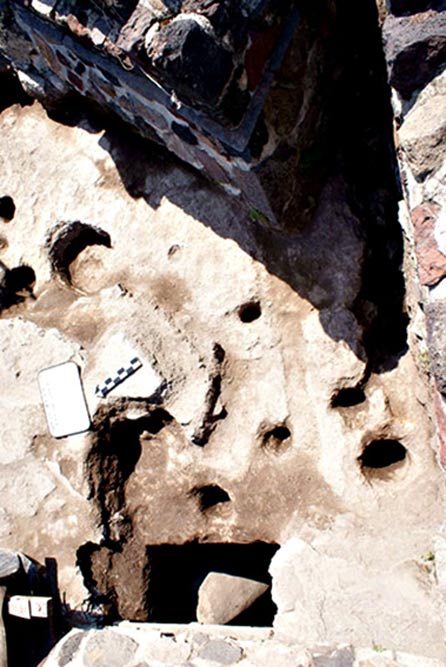 Some of the craters in the limestone and one of the holes with a green stela in the southern part of Structure A.