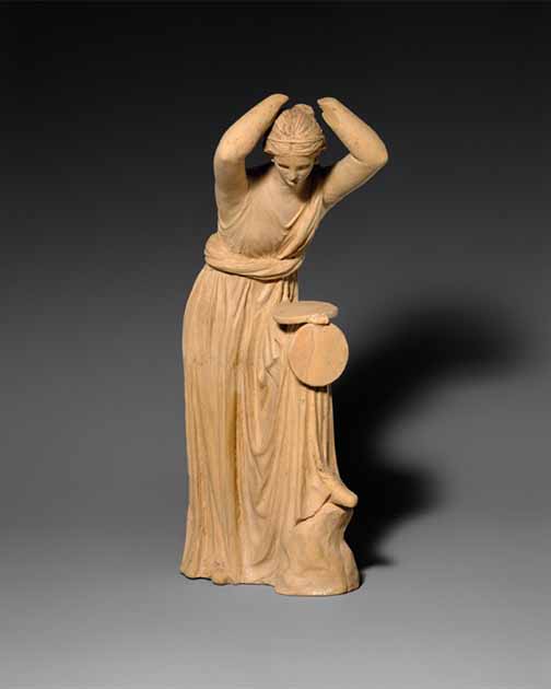 Terracotta statuette of a woman, much like the Hellenistic escort, looking into a box mirror. (Public domain)