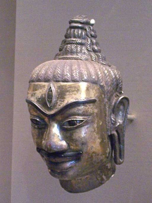 ‘This Cham head of Shiva was made of electrum around 800. It’s a decorated kosa, or metal sleeve fitted to a liṅgam. One can recognize Shiva by the tall chignon hairstyle and by the third eye in the middle of his forehead.’