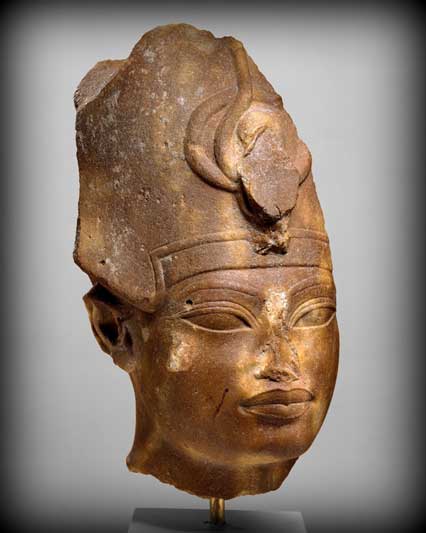 This quartzite head shows King Amenhotep III wearing the Blue Crown (also called the War Crown). The facial features show the stylistic elements of his later representations: highly arched brows, elongated almond-shaped eyes, and full, sharply outlined lips. Metropolitan Museum of Art, New York.