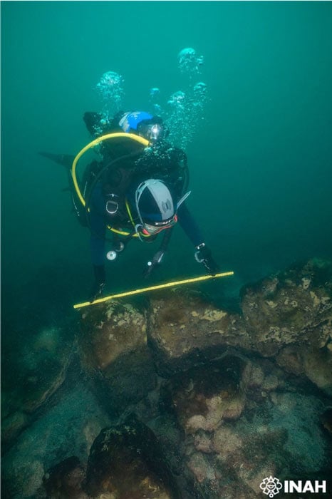 Underwater archaeologist inspecting a remaining wall of the submerged Maya city of Samabaj, in Lake Atitlán, in Guatemala. (INAH)
