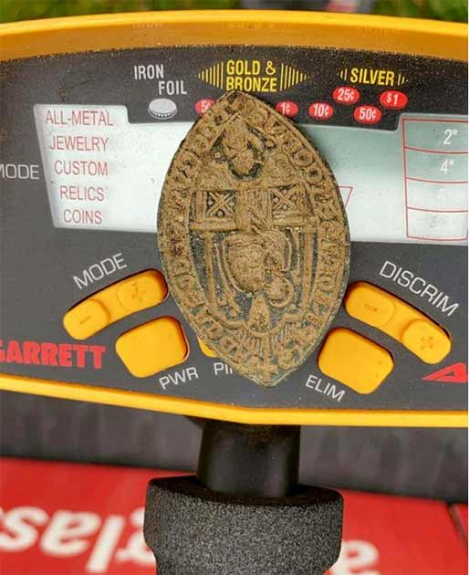 The seal balanced on the lucky metal detector that found it. (Hansons Auctioneers)