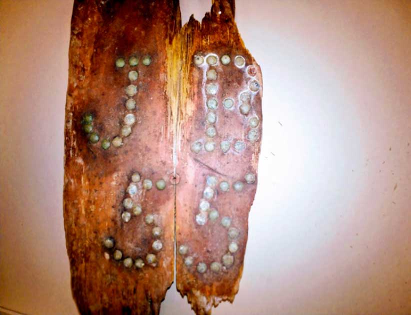 A fragment of the coffin that held the remains of the man believed to be John Barber is hardwood, decorated with brass tacks hammered into the initials 