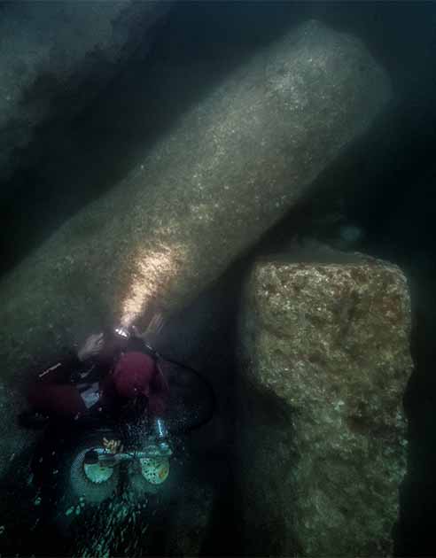 After excavation, an archaeological diver gazes at the huge blocks of the Amun temple, which fell in the mid-second century BC in the South canal of Thonis-Heracleion. They were discovered under 3 m of hard clay. Photo: Christoph Gerigk ©Franck Goddio/Hilti Foundation.