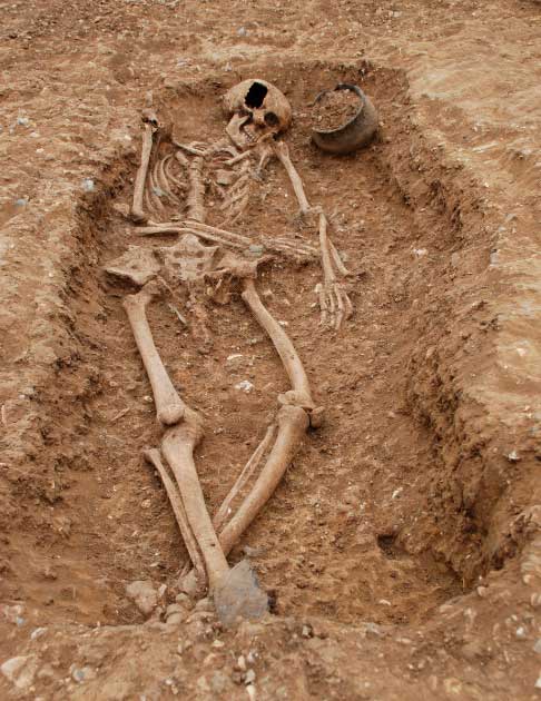 Una antigua tumba anglosajona con una vasija de cerámica, broches y una cuchara romana. Esta tumba (núm. 66) del sitio de Oakington en Cambridgeshire era la de una mujer de ascendencia mixta. (La naturaleza)
