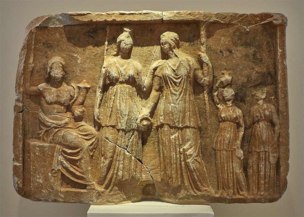 Pluto enthroned with a scepter and cornucopia. In front of him stand Persephone with a scepter and Demeter with a bowl and torch from Tegea. National Archaeological Museum of Athens. Athens, Greece (George E. Koronaios/ CC BY-SA 4.0)