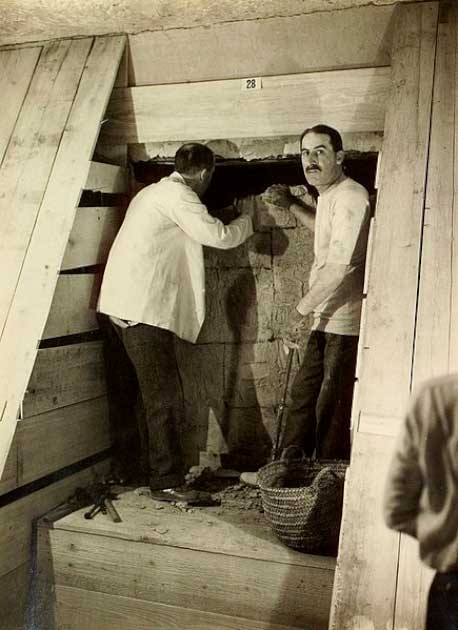 Una de las dos únicas imágenes que muestran a Howard Carter (izquierda) y Lord Carnarvon juntos en la tumba. Comienzan el proceso de desmantelamiento del muro entre la antecámara y la cámara funeraria. (Dominio publico)
