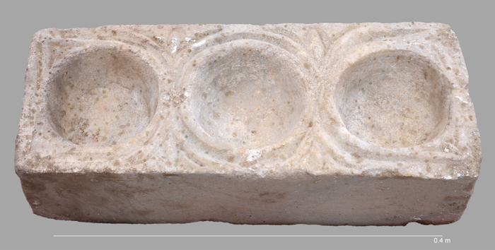 The rectangular marble block featuring three hemispheric cavities