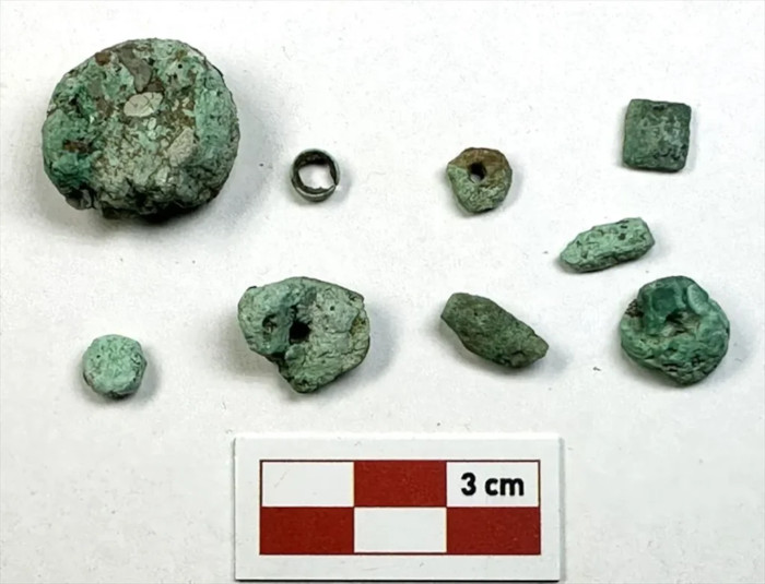 9,000-Year-Old Çayönü Copper Workshop Discovered A stone-paved workshop discovered at Çayönü Tepesi has brought to the fore raw malachite, partially manufactured artifacts, copper beads and other tinny copper products, thus exhibiting a privileged perspective on the Neolithic craft production system. Çayönü copper workshop covering the area of around 5 square meters in southeastern Turkey is dated to approximately 6900-6800 BC according to what was announced by Culture and Tourism Minister Mehmet Nuri Ersoy. The discovery presents not simply information about what and how people produced copper, but also where production took place. • Copper Mining Boom Across Britain 3,600 Years Ago Found in New Study • The Lost Iberian Civilization of Los Millares: Was Copper the Secret of its Success? Stone paving marks the small production area uncovered in the settlement’s western sector. (Republic of Türkiye Ministry of Culture and Tourism) A Purpose-Built Neolithic Workspace During the 2026 excavation, the workshop was discovered at the western section of the settlement by a team of archaeologists supervised by Associate Professor Savaş Sarıaltun of Çanakkale Onsekiz Mart University. Six postholes were found around the paved area, with maybe more that existed, indicating that the workshop was probably covered with a light roofing structure. The layour of the structure is a part of the larger context of the Neolithic revolution in Anatolia when the first permanent settlements appeared and developed new architecture, food production and crafts. 18 pieces of malachite were sourced from the heart of the site, while approximately 24 to 25 pieces were discovered inside the workshop or in the surrounding area. Most importantly, the surrounding area has yielded around 42 pieces of malachite and copper, Anadolu Agency reported. Their concentration and range (from raw mineral to finished objects) indicate the site was a copper workshop rather than a chance scattering of discarded ornaments. • 'They weren't burned by accident': 5,500-Year-Old Pyrenees Cave Camp Uncovered • Neolithic Twin of Knossos: First 8,800-Year-Old Farming Houses Discovered in Turkey Worked and perforated malachite pieces lie beside a small copper bead and scale. (Republic of Türkiye Ministry of Culture and Tourism) Copper Working Is Not Copper Smelting Malachite is a green mineral that contains copper and could be worked into jewelry by prehistoric humans, by grinding, drilling and polishing, as evidenced by the find of a copper smelting site in the Pyrenees. The pure copper formed from native copper ore could be forged directly into tools without the need for smelting. The ancient North American copper mining and metallurgy industry illustrates the difference between these two processes. So the Çayönü assemblage is viewed as recording sophisticated material knowledge long before the mature technologies associated with the Copper Age. As of now, there are no reports of a furnace, crucible or any other indicatives of the smelting process. A study conducted in 2025 has raised the need for distinguishing between cold working, heat treatment process and the chemical reduction of ore. In order to find out the exact processes for obtaining and shaping copper, scientific investigations need to be carried out. Two Millennia of Technical Knowledge According to Ersoy, copper and malachite use in Çayönü goes back at least 9100 BC. “The new discovery reveals that the mining tradition here continued for approximately 2,000 years and that specialized production activities were carried out in designated working areas,” he said, as quoted by Anadolu Agency. This emerging data provides confirmation for previous assertions regarding the importance of Çayönü, Nevalı Çori, and Göbekli Tepe in terms of great Neolithic inventions. An initial study of metallurgy at Çayönü revealed the presence of hundreds of already finished and unfinished malachite beads plus copper beads and tools retrieved from previous excavations. The continuing practice of radiocarbon dating together with archaeometric studies should help establish the timeline of this new workshop and determine if the items produced there were beaten or made through heating, or used some other technology. However, the most important aspect of this workshop is its location; thanks to the organized workplace, we witness actions occurring during one of the earliest encounters with metal. By contrast with any single artifact, the restricted setting enables archaeologists to connect raw materials with the products and the process that crafters have made in one chain of decisions. Top image: An excavator examines a malachite fragment from the 9,000-year-old Çayönü copper workshop. Source: Republic of Türkiye Ministry of Culture and Tourism By Gary Manners References Altuntaş, L. 2026. 9,000-Year-Old Malachite and Copper Workshop Discovered at Çayönü Tepesi. Available at: https://www.anatolianarchaeology.net/9000-year-old-malachite-and-copper-workshop-discovered-at-cayonu-tepesi/ Candan, F. N. and Çanakcı, B. 2026. 9,000-year-old mining workshop found in Türkiye. Available at: https://www.aa.com.tr/en/turkiye/9-000-year-old-mining-workshop-found-in-turkiye/4043827 Ersoy, M. N. 2026. Çayönü Tepesi’nde insanlık tarihinin en erken üretim teknolojilerine ışık tutan önemli bir keşfi daha gün yüzüne çıkardık. Available at: https://x.com/MehmetNuriErsoy/status/2094681965999927360 Muşkara, Ü., Karayünlü Bozbaş, S., Telli, M. B. and Konak, A. 2025. Early copper production by the last hunter-gatherers. Journal of Archaeological Science: Reports, 62, 105051. Available at: https://doi.org/10.1016/j.jasrep.2025.105051 Özdoğan, M. and Özdoğan, A. 1999. Archaeological Evidence on the Early Metallurgy at Çayönü Tepesi. In A. Hauptmann, E. Pernicka, T. Rehren and Ü. Yalçın (eds ), The Beginnings of Metallurgy, Der Anschnitt, Beiheft 9, pp. 13–22. Bochum: Deutsches Bergbau-Museum. Available at: https://www.academia.edu/32222879/Archaeological_Evidence_on_the_Early_Metallurgy_at_C_ayo_nu_Tepesi_pdf