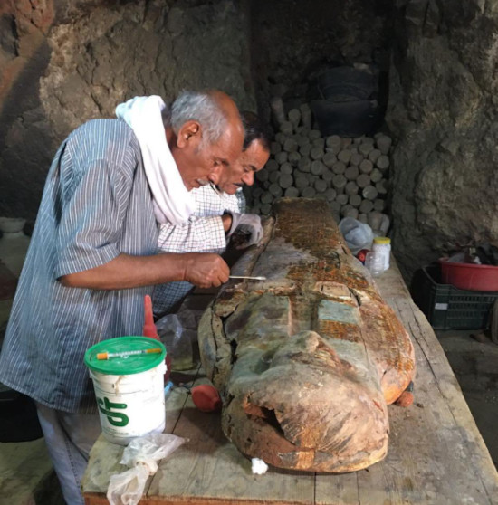 Expert working on preservation of a coffin