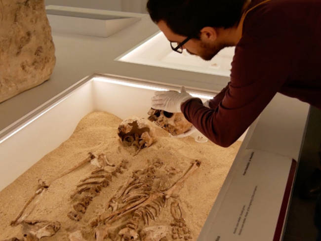 Daniel Fernandes preparing to take a sample from the skeletal remains from Romito Cave