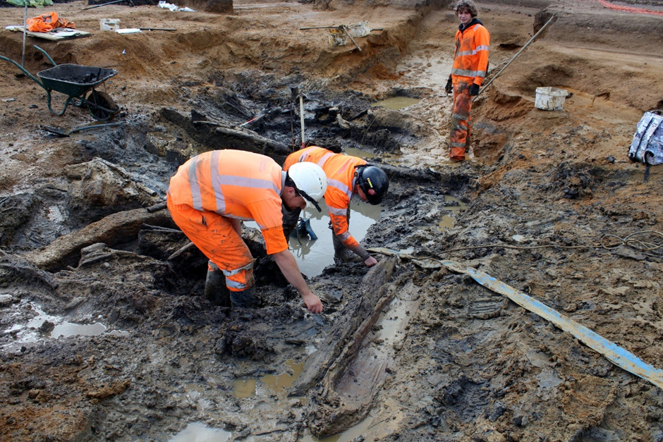Archaeologists digging to deeper layers of woodwork at the well.