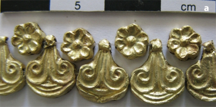 Gold beads of a necklace, in rosette and lily designs