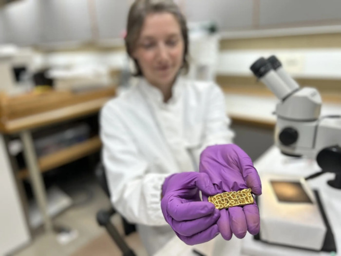 Researcher and conservator Hege Hollund from the Museum of Archaeology, University of Stavanger presents the gold sword scabbard ornament. Credit: Terje Tveit / Museum of Archaeology / University of Stavanger.