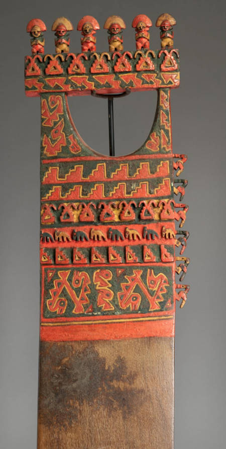 This decorated wooden object from Chincha, which has been interpreted as either a ceremonial paddle or digging stick, depicts seabirds and fish alongside human figures and geometric designs