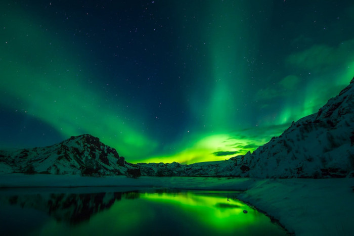 A stunning view of the Aurora Borealis over a snowy Arctic landscape,