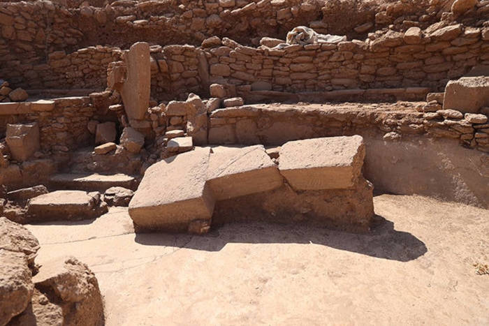 Three-tiered stone benches curve toward a central sculpture,