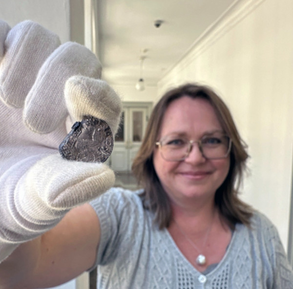 Gitte Tarnow Ingvardson, curator at the National Museum of Denmark holding one of the coins